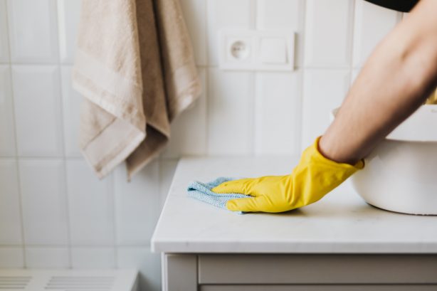 Person cleaning surface near a sink